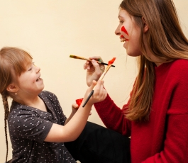 happy woman girl with down syndrome painting each other s faces