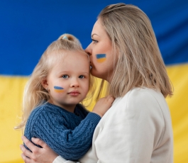medium shot ukranian mother kissing kid