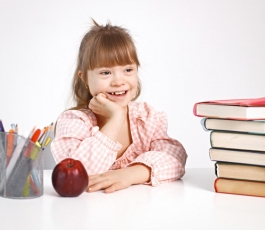 girl with down syndrome studying while sitting desk home